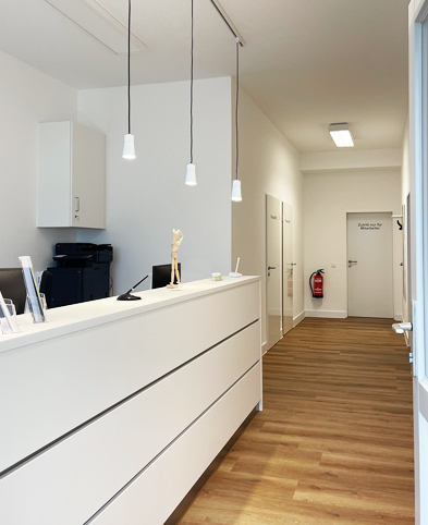 Das Foto zeigt den Empfangsbereich der Zweigpraxis Allgemeinmedizin Erkrath – hell und freundlich gestalteter Eingang der Praxis.